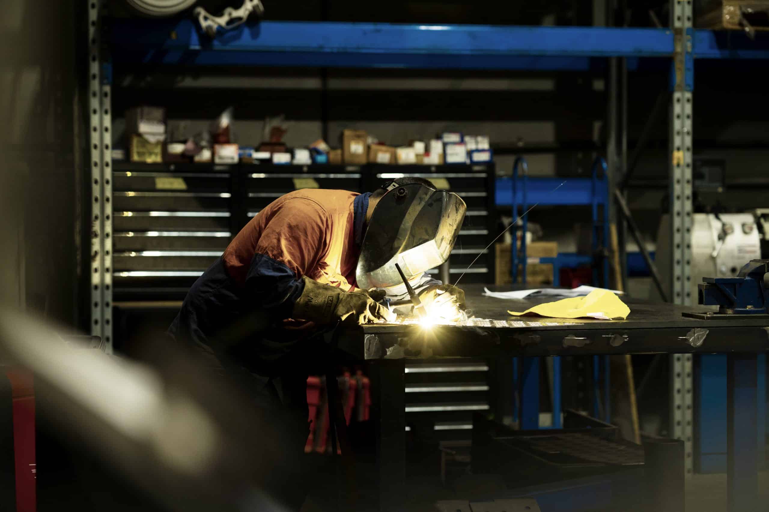 keenworx custom metal work man in workshop cutting metal
